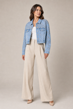 Load image into Gallery viewer, Embellished Light-Wash Denim Layering Jacket styled on model against a stone gray studio background