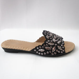 Black slip-on flat sandals embellished with silver crystals.