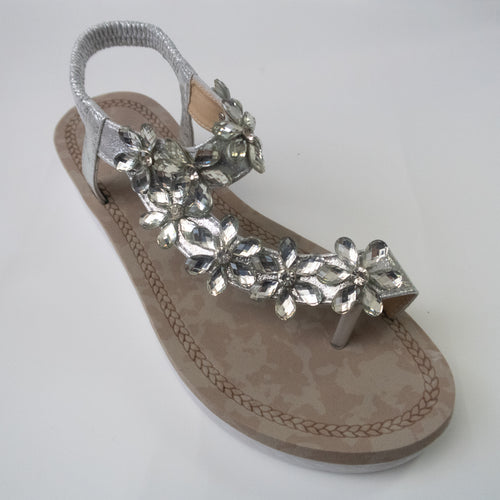 A silver toe-ring sandal with crystal flower embellishments trailing from the toe-ring to upper-strap.