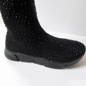 Black knee-high sock sneaker boot hybrid with crystal embellishments. Stretchy sock-knit upper embellished with black crystals. Pull-on style. Black sneaker-like soles.