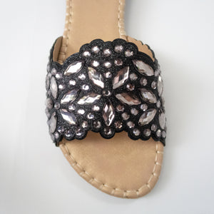 Black slip-on flat sandals embellished with silver crystals.