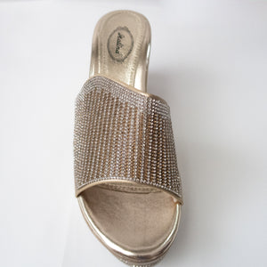 Gold slip-on wedges with crystals embellishing the upper strap. (birds-eye view)