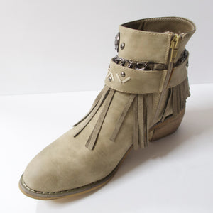 Tan/beige ankle booties with fringe design and embellished strap upper. Suede-like material. Slight heel. Decorated upper with a chain, embellished strap, and fringe. Inner side-zipper.